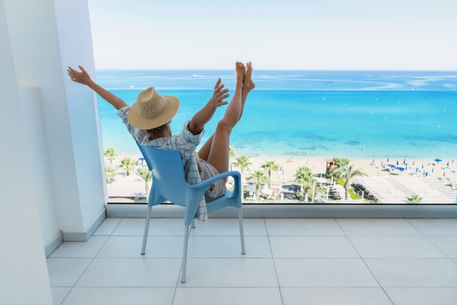 Young woman on a modern designed chair enjoying summer apartment in Bulgaria with a sea view